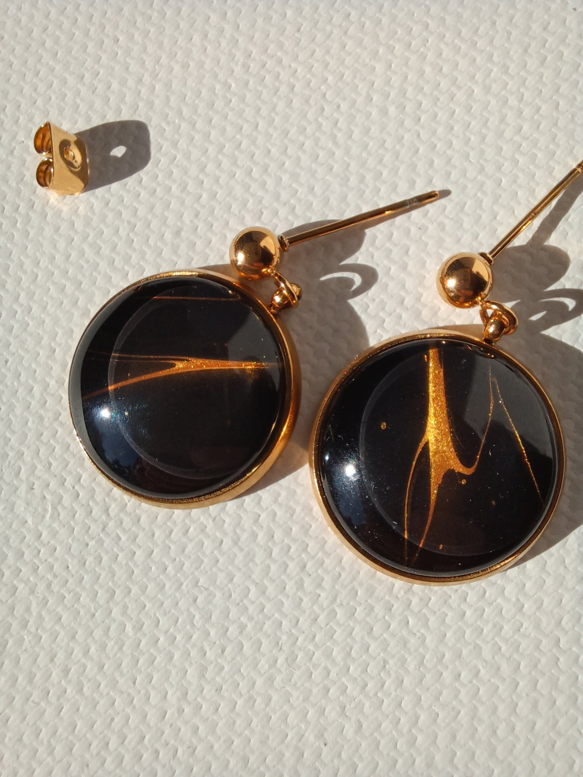 Boucles d'oreilles rondes Galaxia, doré et noir, paire recto gros plan